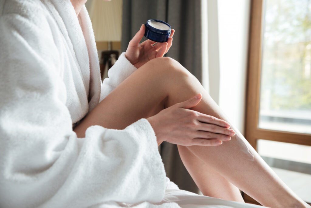mujer poniéndose crema corporal